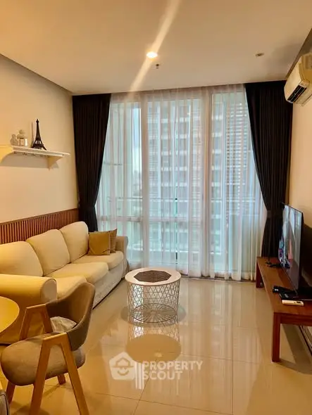 Modern living room with large windows and stylish furniture in a high-rise apartment.