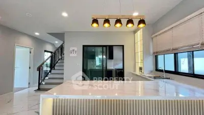 Modern kitchen with marble island and stylish lighting in open layout home