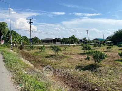 Expansive land plot with lush greenery and clear blue sky, ideal for development or agriculture.