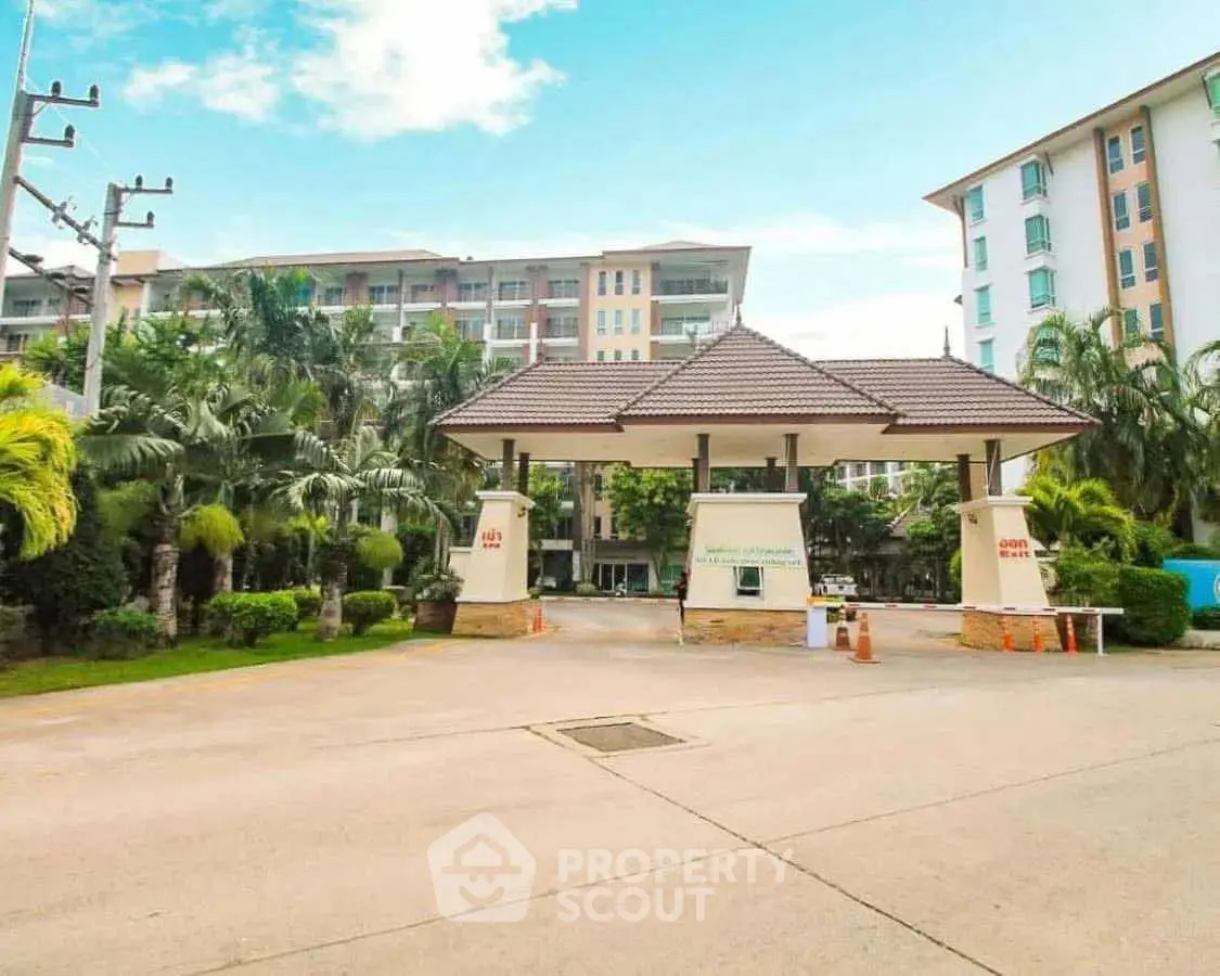 Modern condominium entrance with lush landscaping and clear blue sky