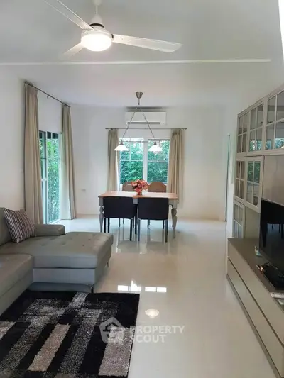 Spacious living room with modern decor and large windows offering natural light.