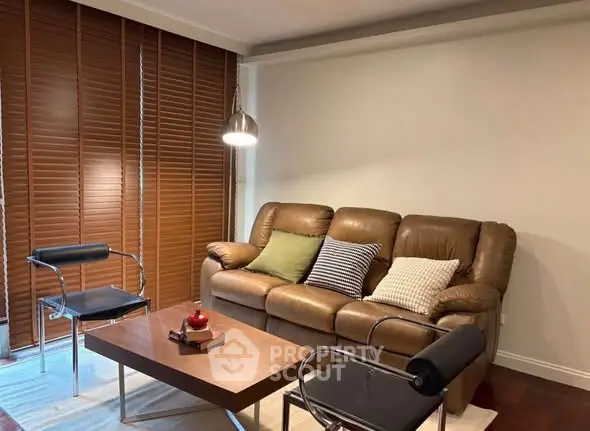 Stylish living room with leather sofa and modern chairs, perfect for relaxation.
