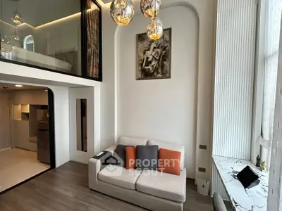 Modern living room with high ceilings, mezzanine, and stylish lighting in a chic apartment.