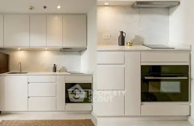 Modern kitchen with sleek cabinetry and built-in oven, perfect for contemporary living.