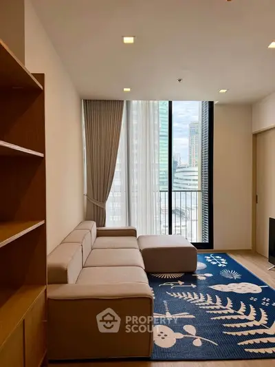 Modern living room with large window and city view, featuring a stylish sofa and decorative rug.