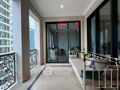 Luxurious balcony with elegant seating and stunning city views in high-rise apartment.