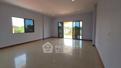 Spacious empty living room with large windows and balcony access