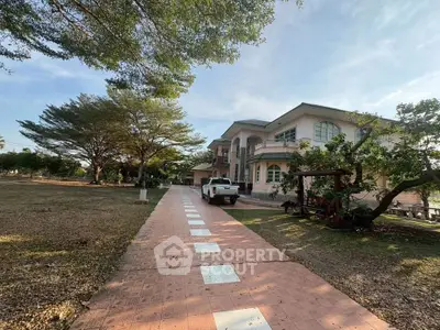 Stunning two-story house with spacious driveway and lush greenery, perfect for serene living.