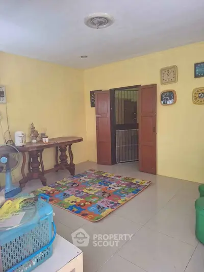 Charming living room with colorful play mat and vintage wooden table, perfect for family gatherings.