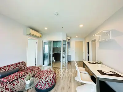 Modern open-plan living room with stylish furniture and integrated kitchen area.