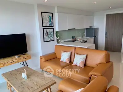 Modern living room with leather sofas and open kitchen layout in stylish apartment.