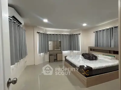 Spacious bedroom with modern furnishings and ample natural light, perfect for relaxation and comfort.