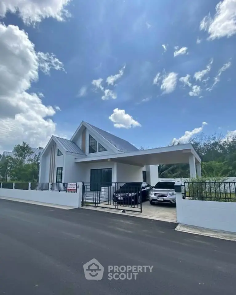 Modern white house with sleek design and spacious driveway under a clear blue sky.