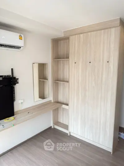 Modern bedroom with built-in wardrobe and air conditioning unit, perfect for comfortable living.