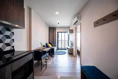 Modern living room with open layout and stylish decor, featuring a cozy seating area and balcony access.