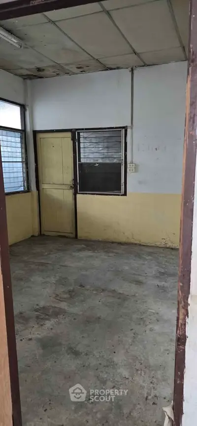 Spacious room with potential for renovation, featuring large windows and ample natural light.