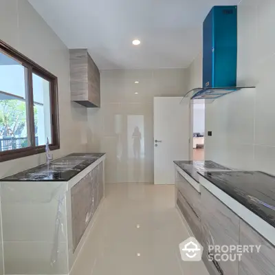 Modern kitchen with sleek cabinetry and large window for natural light