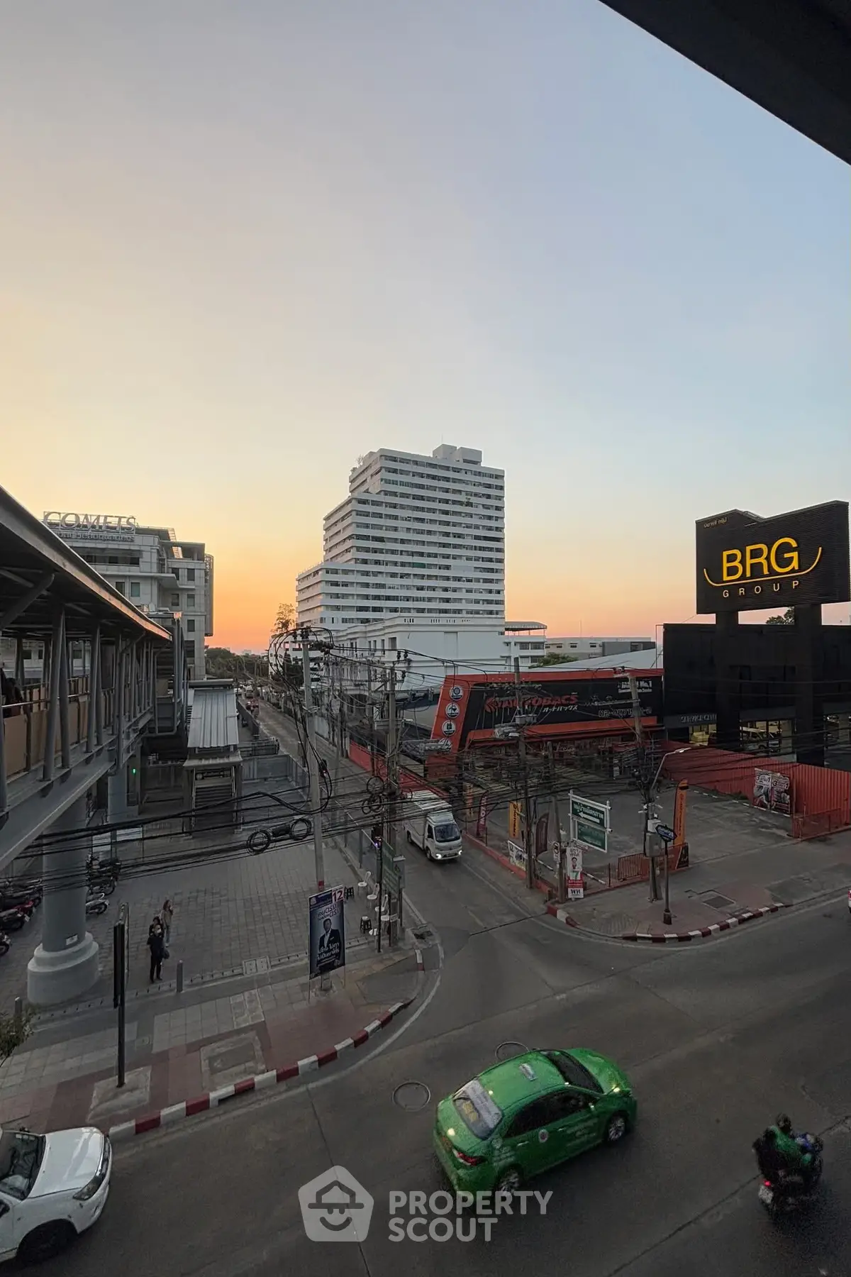 Urban cityscape with modern buildings at sunset, featuring a bustling street view.
