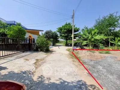 Charming rural property entrance with lush greenery and open sky, perfect for serene living.