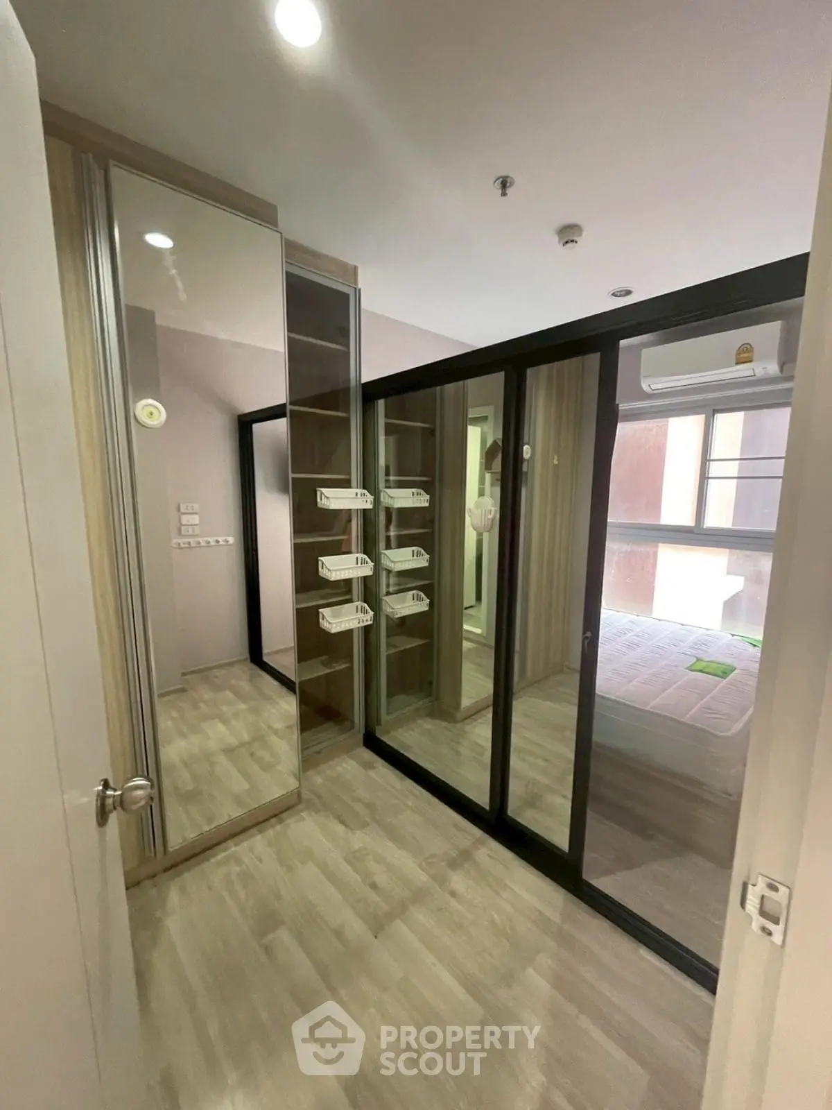 Modern bedroom with mirrored closet and wooden flooring
