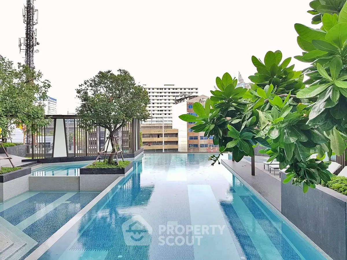Luxurious rooftop pool with lush greenery and city views, perfect for relaxation and leisure.