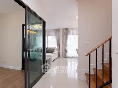 Modern interior with glass sliding doors and elegant staircase in a bright living space.