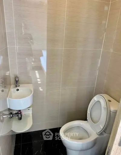 Compact modern bathroom with sleek fixtures and tiled walls, ideal for urban living spaces.