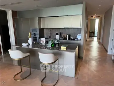 Luxurious modern kitchen with sleek design and high-end appliances, featuring an elegant island and stylish bar stools.