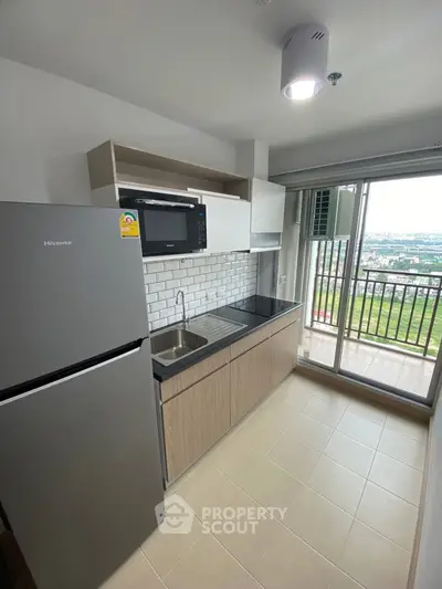 Modern kitchen with balcony view, featuring sleek appliances and stylish cabinetry.