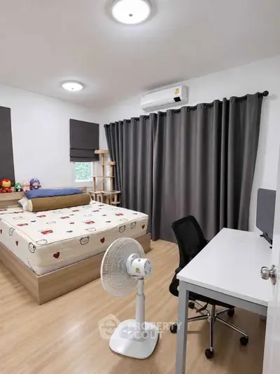 Cozy bedroom with modern decor, featuring a comfortable bed, desk, and air conditioning.