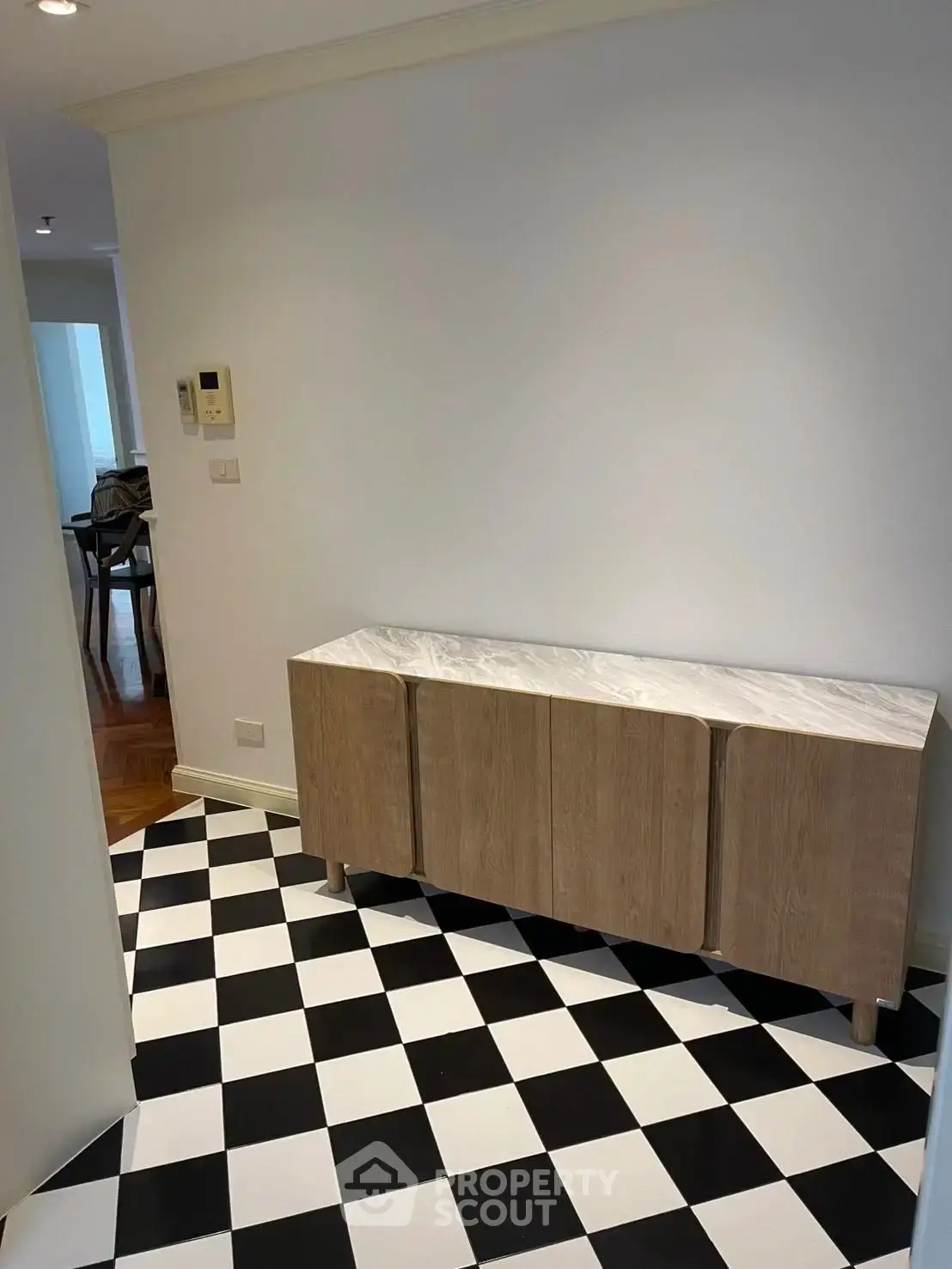 Stylish interior hallway with checkered floor and modern wooden console table.