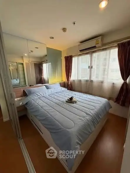 Cozy bedroom with large windows and mirrored closet doors, featuring a comfortable bed and soft lighting.