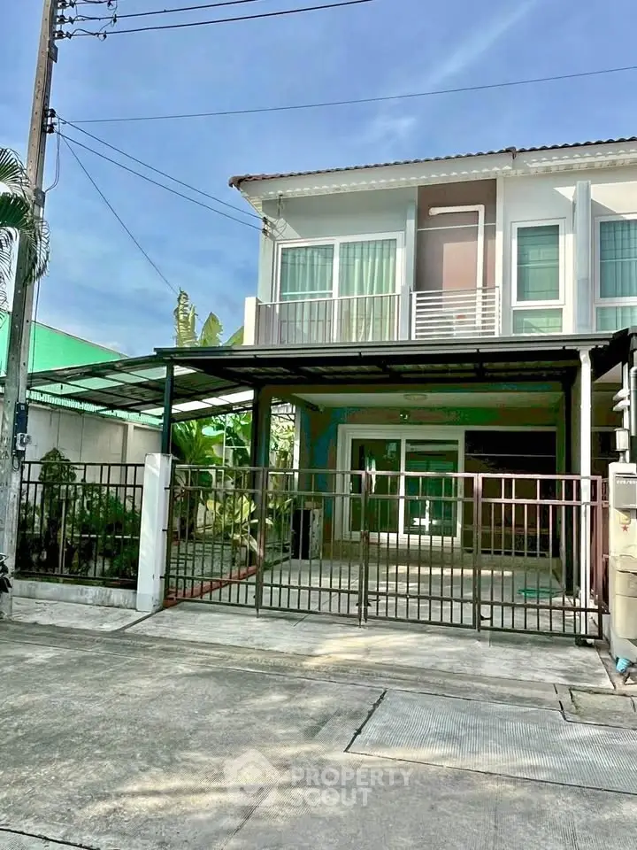 Charming two-story house with gated driveway and modern facade in a serene neighborhood.