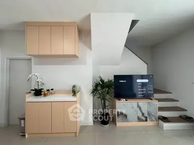 Modern living room with sleek cabinetry and stylish staircase
