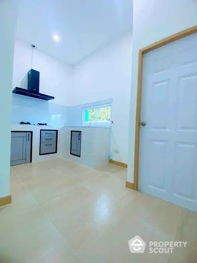 Modern minimalist kitchen with sleek cabinetry and gas stove, featuring a bright and airy atmosphere.