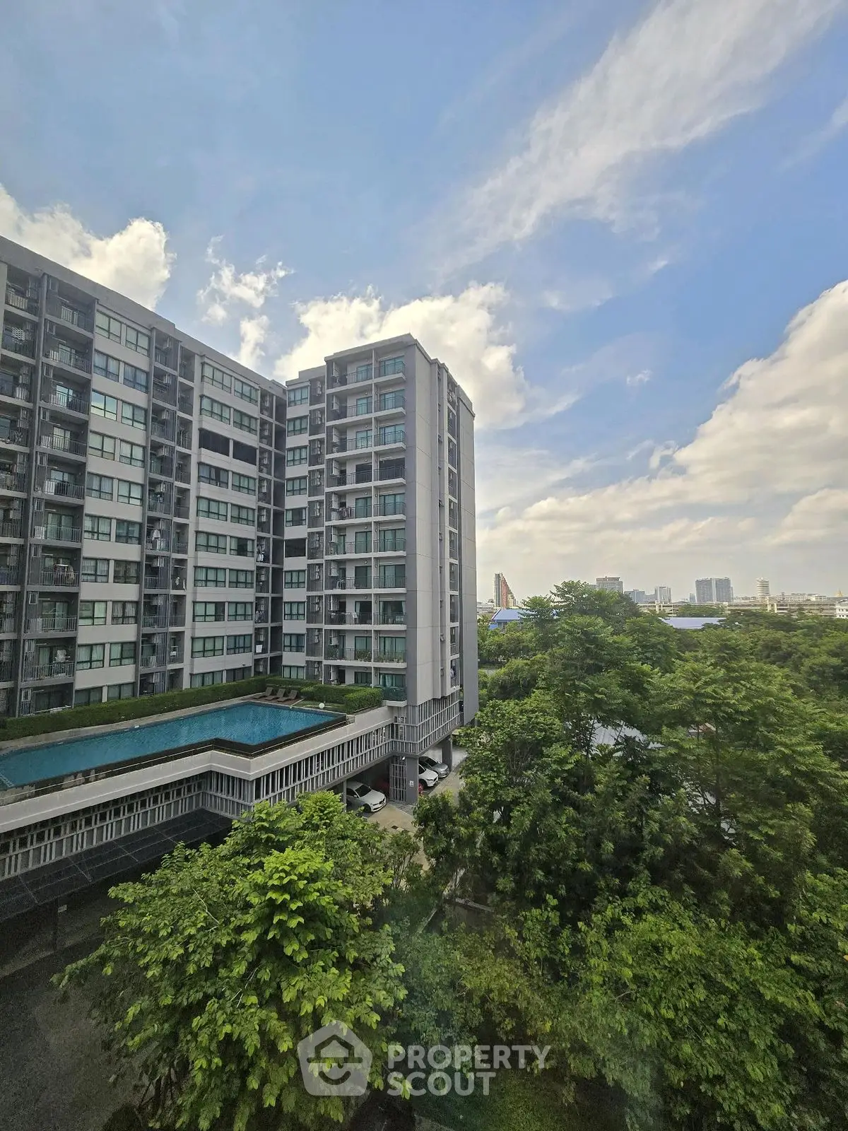 Stunning high-rise building with lush greenery and cityscape view, perfect for urban living.