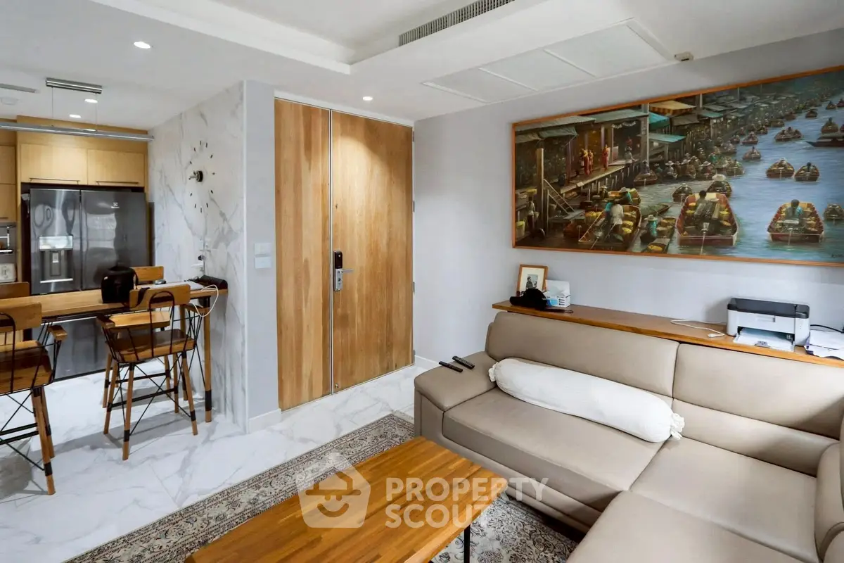 Modern living room with open kitchen, featuring sleek furniture and stylish decor.