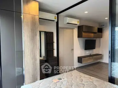 Modern bedroom with sleek design, featuring built-in storage and air conditioning units.