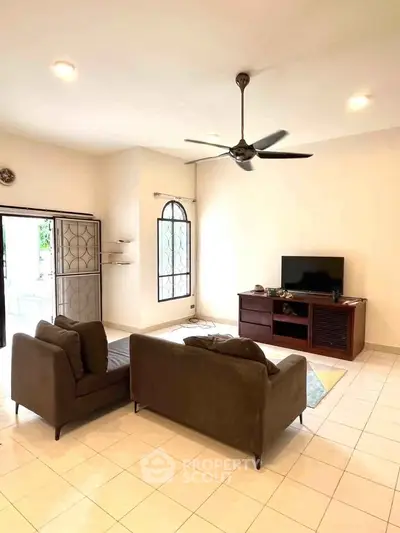 Spacious living room with modern furniture and ceiling fan, perfect for relaxation and entertainment.