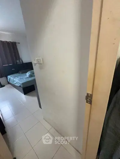 Cozy bedroom with tiled flooring and natural light, ideal for comfortable living.