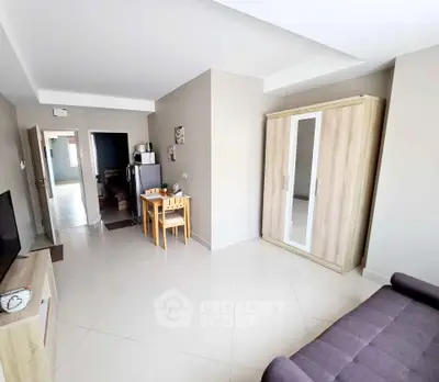 Modern living room with sleek furniture and neutral tones, featuring a cozy dining area and ample storage space.