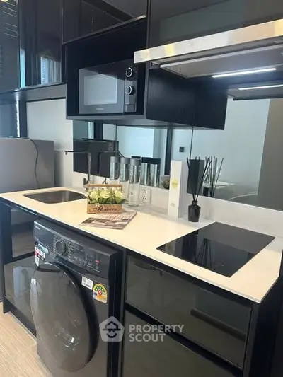 Modern kitchen with sleek appliances and stylish black cabinetry