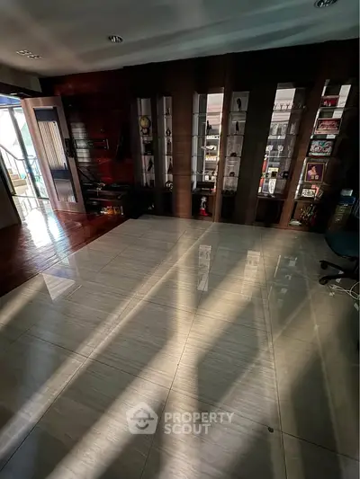 Spacious living room with elegant shelving and ample natural light