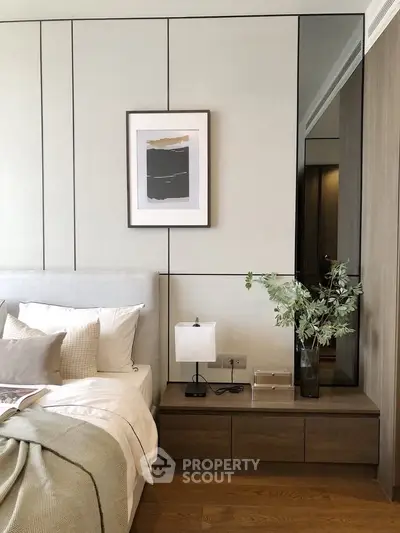Elegant bedroom with modern decor, featuring a cozy bed, stylish nightstand, and contemporary wall art.