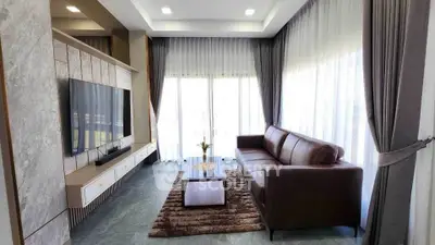 Luxurious living room with modern decor, large windows, and elegant furnishings.