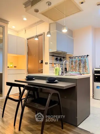 Modern kitchen with sleek design, featuring an island and stylish lighting, perfect for urban living.