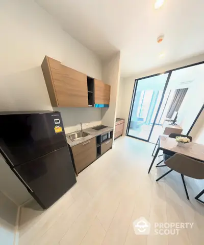 Modern kitchen with sleek cabinets and dining area in bright apartment