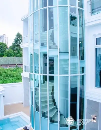 Stunning modern glass staircase exterior with pool view in luxury property