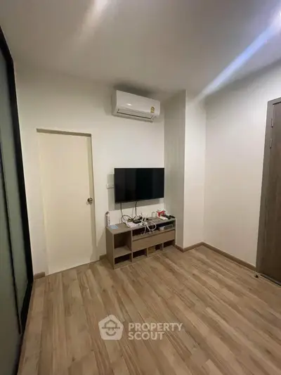 Modern living room with sleek TV setup and air conditioning, perfect for cozy relaxation.