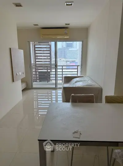 Modern living room with balcony view and sleek furniture in urban apartment.